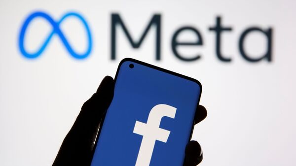 Smartphone com logotipo do Facebook em frente de um logotipo do Meta, novo nome da empresa Facebook, 28 de outubro de 2021 - Sputnik Brasil
