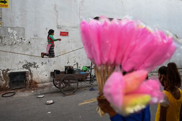 Menina se equilibra em uma corda durante um espetáculo de rua em Nova Deli, Índia. - Sputnik Brasil