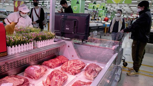 Clientes usando máscara compram carne em um supermercado em Pequim na segunda-feira, 16 de março de 2020 - Sputnik Brasil