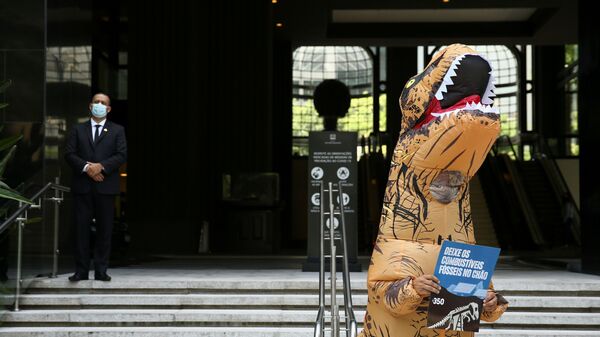 Ativista fantasiado de dinossauro protesta contra exploração de combustíveis fósseis na região da Amazônia, São Paulo, 5 de novembro de 2021   - Sputnik Brasil