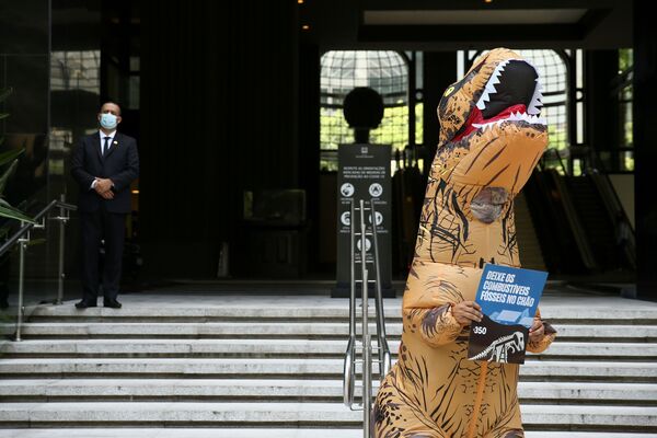 Ativista fantasiado de dinossauro protesta contra exploração de combustíveis fósseis na região da Amazônia, São Paulo, 5 de novembro de 2021. - Sputnik Brasil