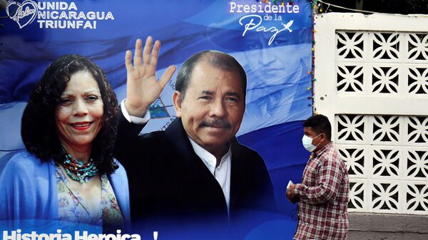 Um homem passa por uma faixa que representa o presidente da Nicarágua, Daniel Ortega, e a vice-presidente Rosario Murillo, antes das últimas eleições presidenciais do país, em Manágua, Nicarágua, 2 de novembro de 2021 - Sputnik Brasil