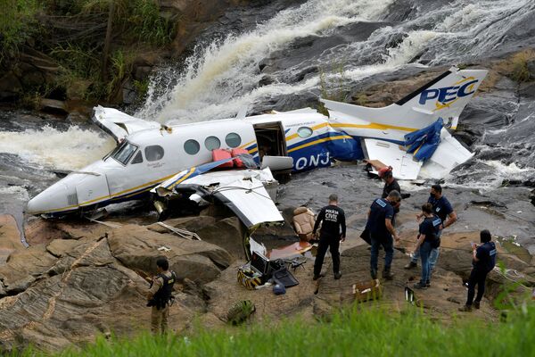 Policiais investigam destroços do pequeno avião que caiu com a cantora Marília Mendonça em Piedade de Caratinga, no estado de Minas Gerais, em 6 de novembro de 2021. - Sputnik Brasil
