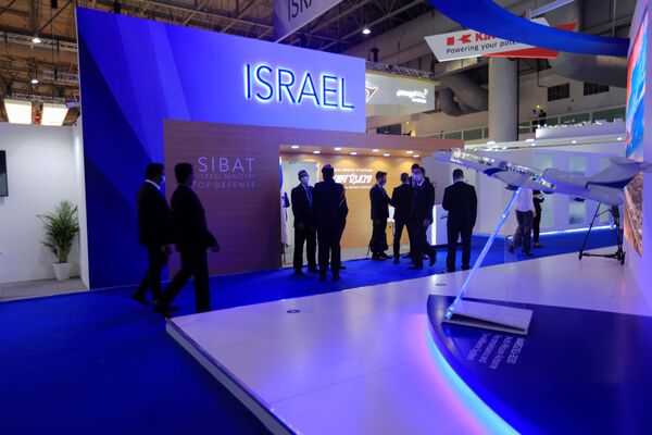 Pessoas passam ao lado de exibição israelense durante Show Aéreo de Dubai, Emirados Árabes Unidos, 14 de novembro de 2021 - Sputnik Brasil