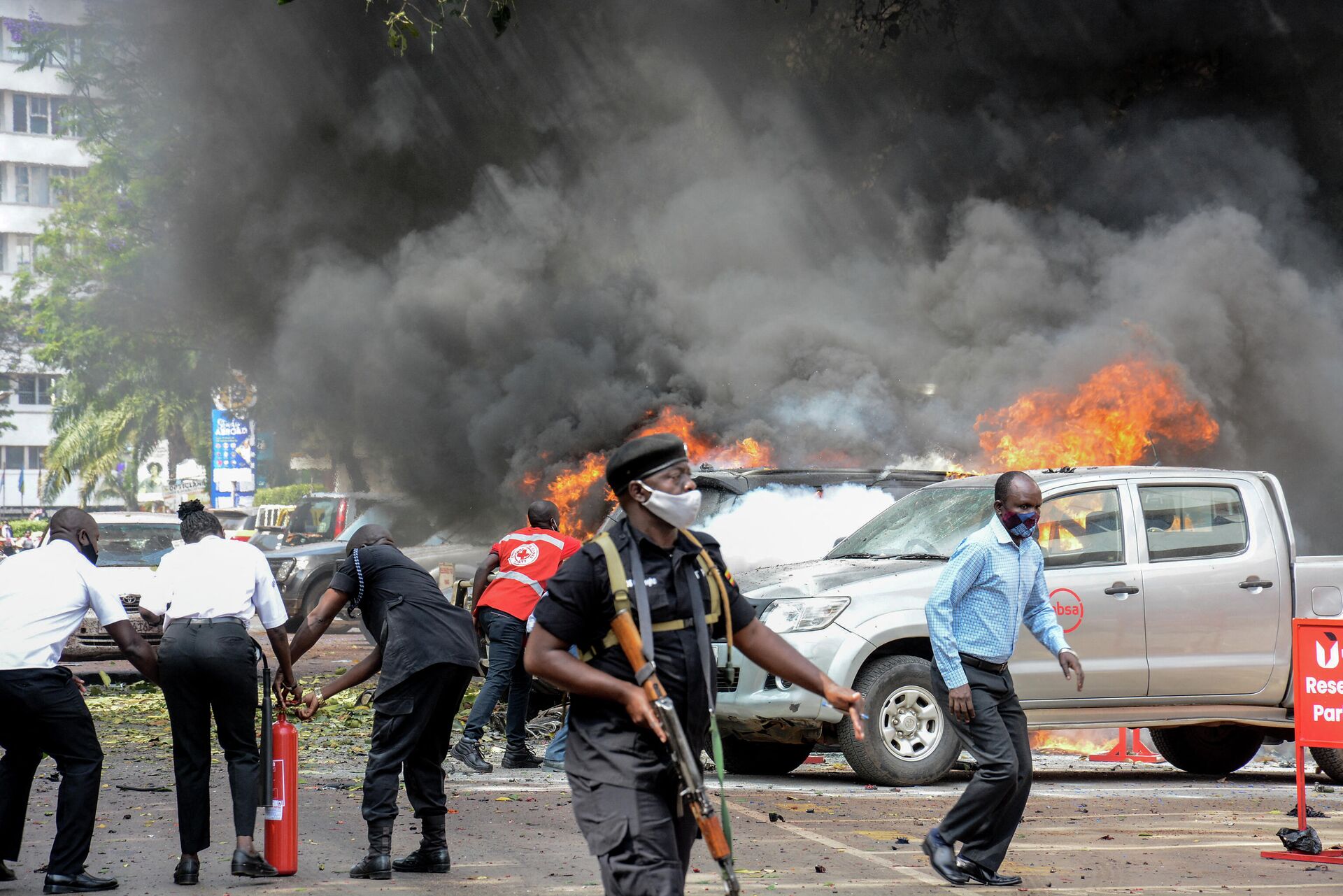 Pessoas apagam chamas após explosão perto do parlamento em Kampala, Uganda, 16 de novembro de 2021 - Sputnik Brasil, 1920, 17.11.2021