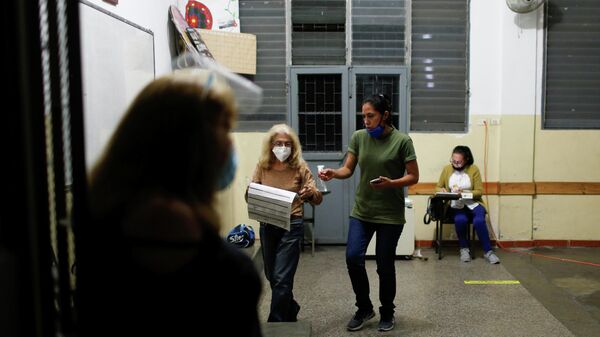 Funcionários eleitorais esperam por encerramento de urna durante eleições regionais e municipais em Caracas, Venezuela, 21 de novembro de 2021 - Sputnik Brasil