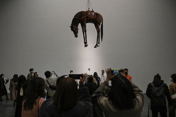 Pessoas tiram fotos de escultura intitulada &quot;Novecento&quot; do artista italiano Maurizio Cattelan durante uma exposição em Pequim. - Sputnik Brasil