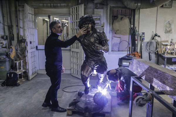 Soldador trabalhando (à direita) com o escultor italiano Domenico Sepe na estátua de bronze da lenda de futebol argentino Diego Armando Maradona. - Sputnik Brasil