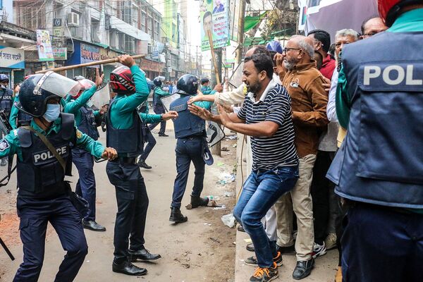 Polícia levanta bastão conta apoiante do Partido Nacionalista do Bangladesh (BNP), enquanto pessoas protestam em manifestação exigindo que o governo autorize o ex-presidente Khaleda Zia a viajar para o estrangeiro para tratamento. - Sputnik Brasil