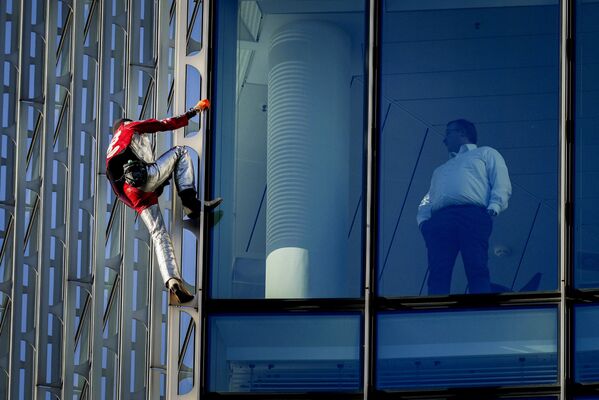 Alpinista urbano francês Alain Robert escala o edifício Skyper no centro de Frankfurt, Alemanha. - Sputnik Brasil