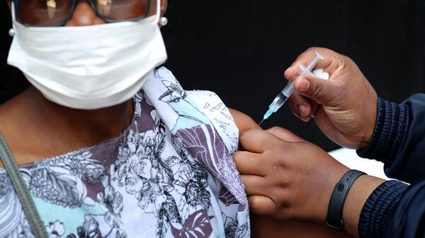 Um profissional de saúde aplica uma dose da vacina da Johnson & Johnson contra a COVID-19 em uma mulher em Houghton, em Joanesburgo, na África do Sul, em 20 de agosto de 2021 - Sputnik Brasil