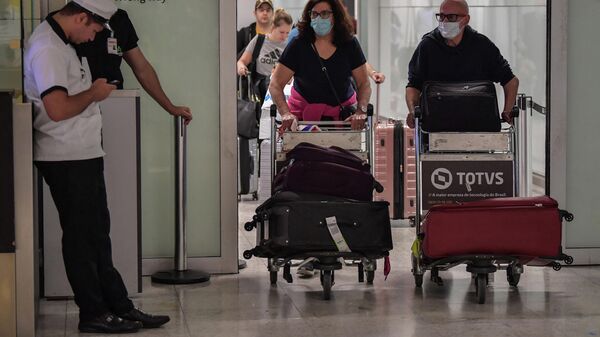 Passageiros usando máscaras como medida de precaução para evitar a contração do novo coronavírus chegam em um voo da Itália no Aeroporto Internacional de Guarulhos, em São Paulo, no dia 2 de março de 2020 - Sputnik Brasil