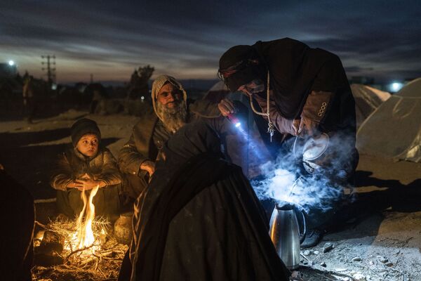 Família prepara chá em acampamento junto do escritório da Direção de Desastre em Herat, Afeganistão, 29 de novembro de 2021 - Sputnik Brasil