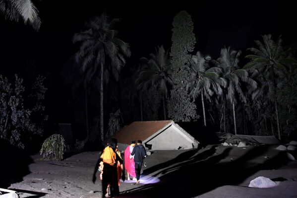 Moradores perto de casa coberta por cinza vulcânica no assentamento de Sumber Wuluj, do distrito de Lumajang, Indonésia, 5 de dezembro de 2021, após erupção do vulcão Semeru - Sputnik Brasil