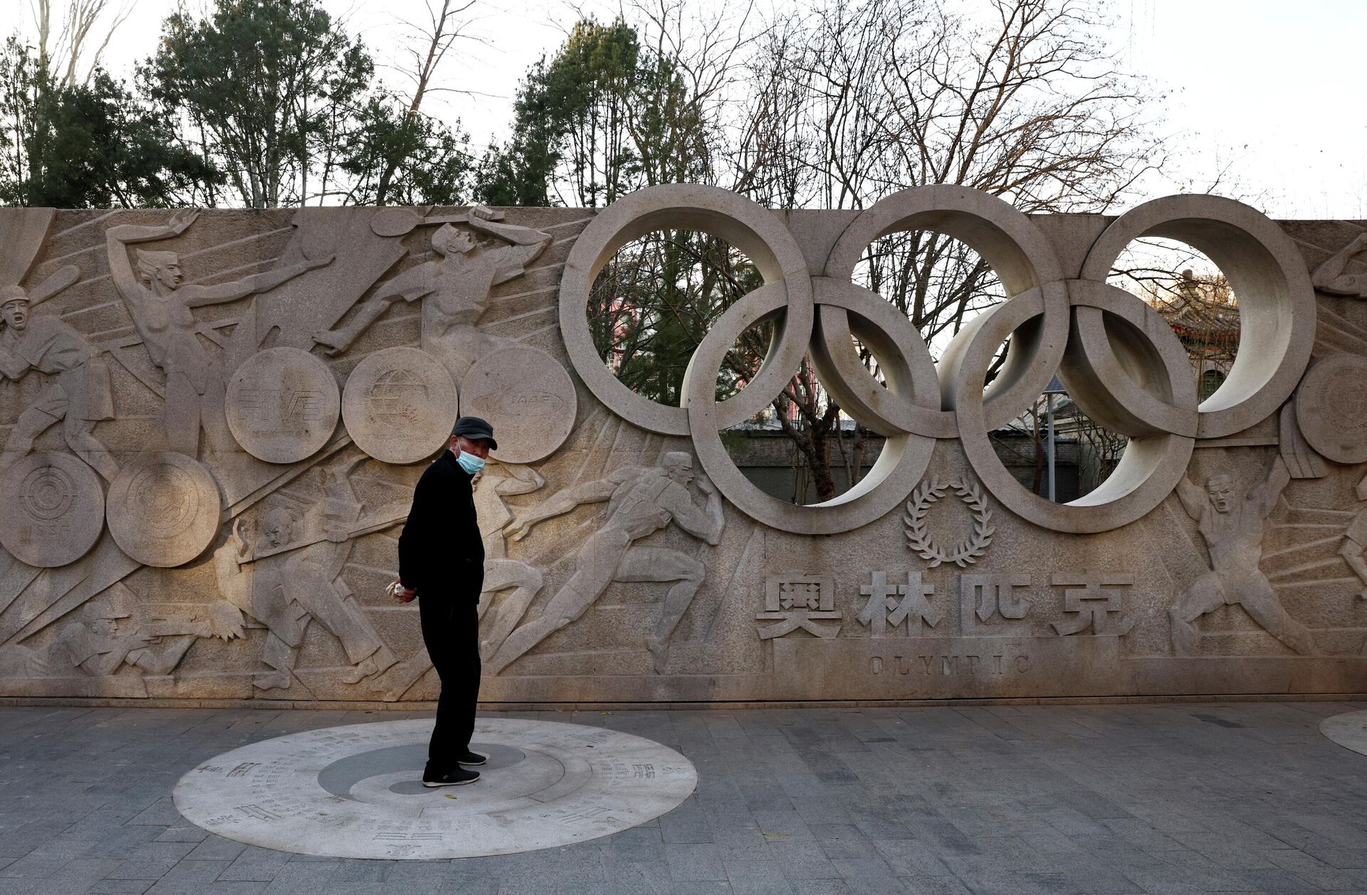Homem em frente a baixo-relevo com Anéis Olímpicos em parque de Pequim, China, 7 de dezembro de 2021 - Sputnik Brasil, 1920, 07.12.2021