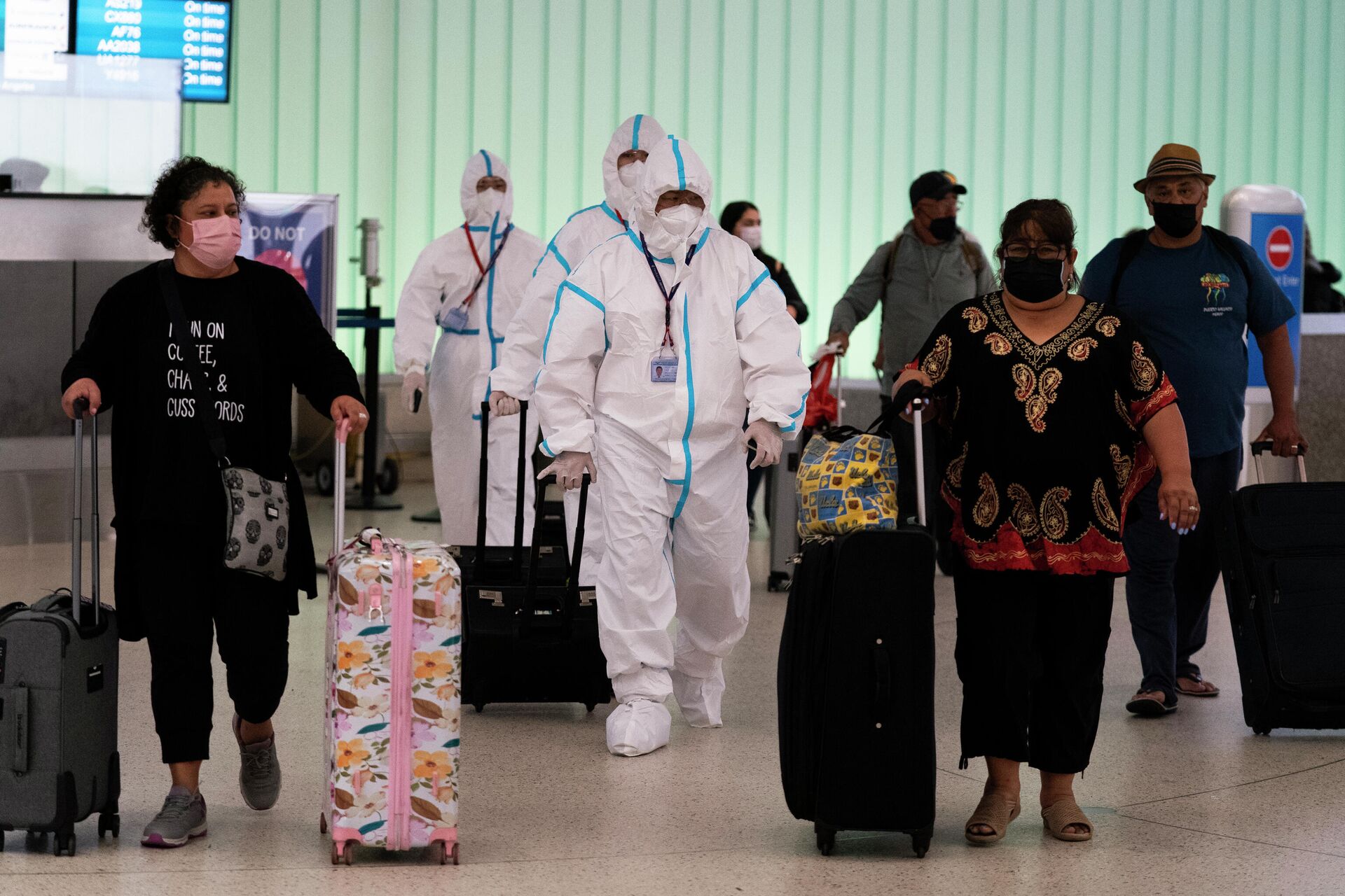 Membros de uma tripulação da Air China em trajes de proteção caminham pela área de chegadas no Aeroporto Internacional de Los Angeles, 30 de novembro de 2021 - Sputnik Brasil, 1920, 07.12.2021