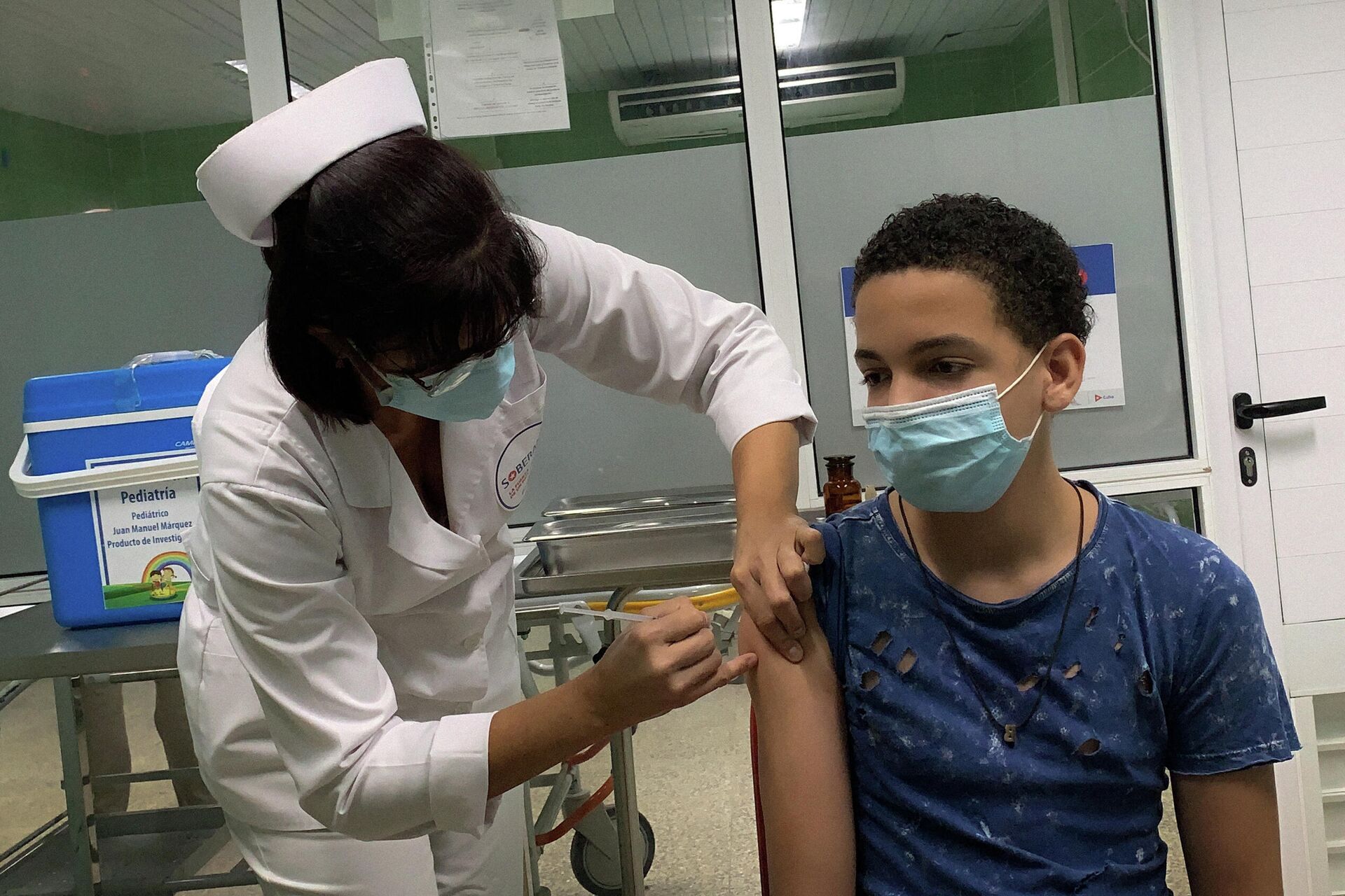 Menino cubano de 13 anos recebe a vacina cubana Soberana Plus contra a COVID-19, em 24 de agosto de 2021, no hospital Juan Manuel Márquez, em Havana, durante os testes do imunizante em crianças e adolescentes - Sputnik Brasil, 1920, 15.12.2021