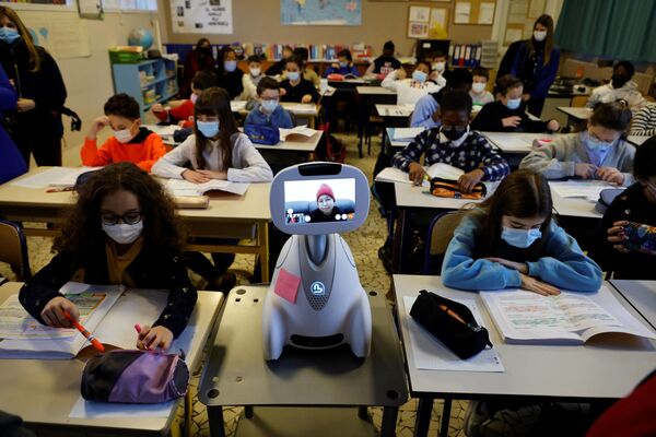 Crianças na sala de aula, enquanto uma estudante participa do processo a partir de casa por meio do robô Buddy, em uma escola primária perto de Paris. - Sputnik Brasil