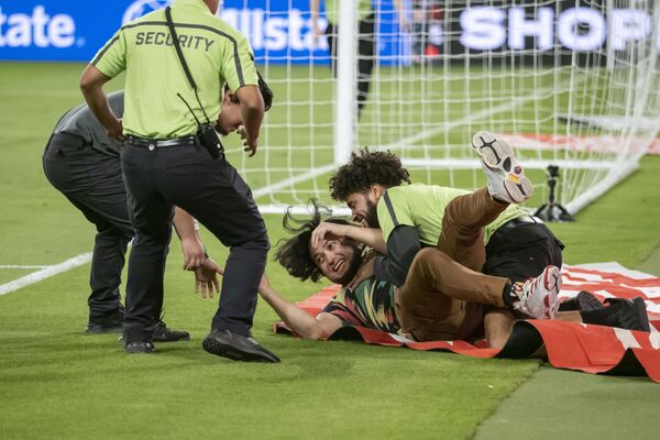 Torcedor derrubado por um segurança depois de entrar em campo em um jogo de futebol amigável entre o México e o Chile. - Sputnik Brasil