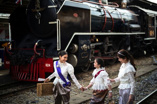 Mulheres vestindo trajes históricos posam ao lado de trem a vapor antes de partir da estação de Hualamphong, Tailândia. - Sputnik Brasil