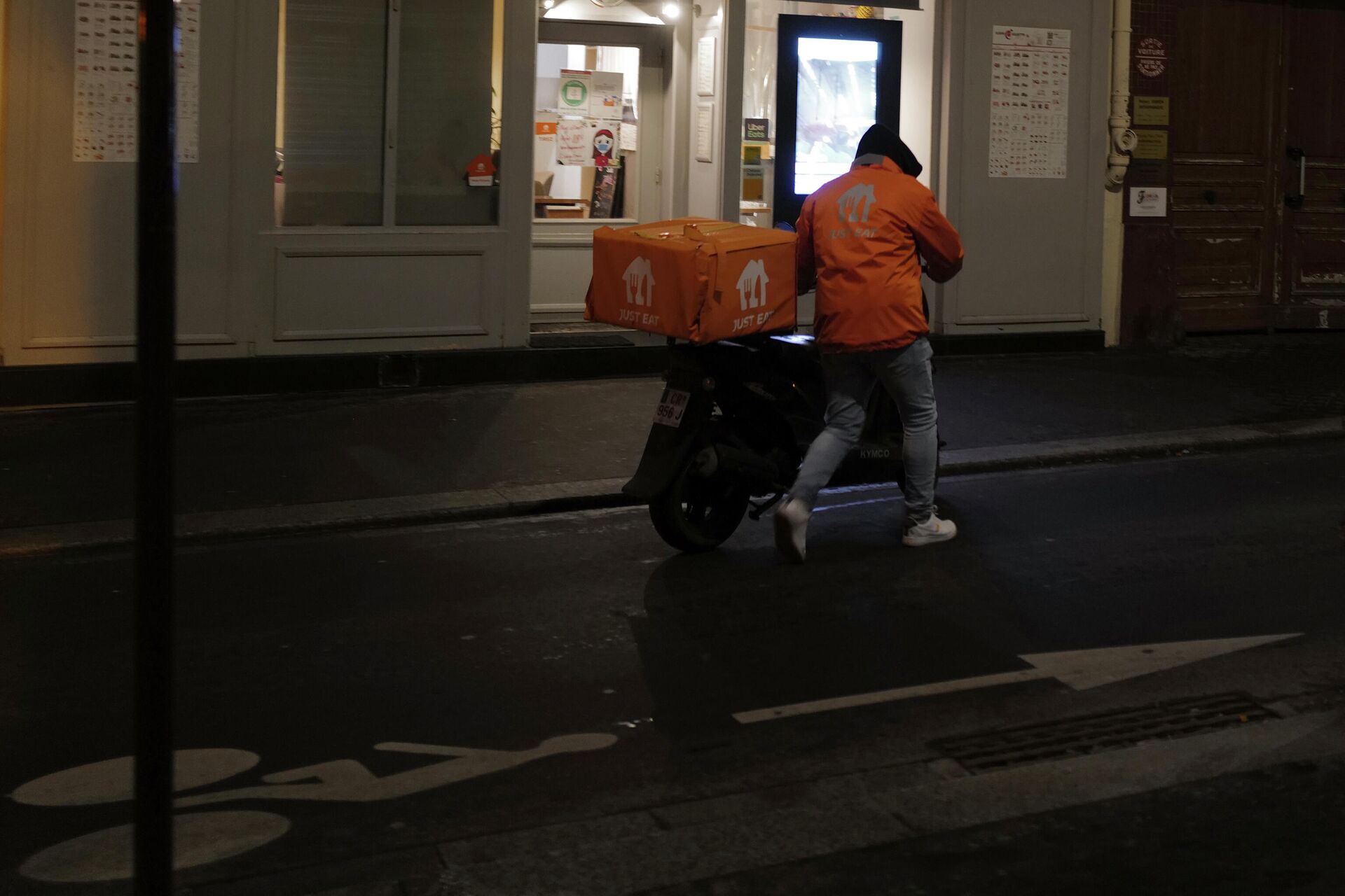 Um entregador de comida empurra sua scooter em frente a um restaurante em Paris, segunda-feira, 15 de fevereiro de 2021 - Sputnik Brasil, 1920, 10.12.2021