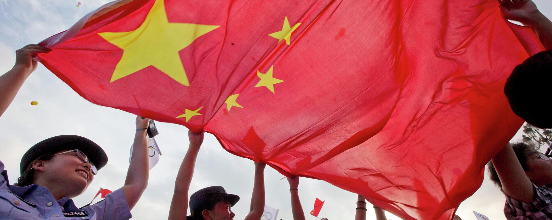 Policiais chinesas agitam uma bandeira nacional chinesa para comemorar enquanto Pequim é anunciada como a cidade-sede dos Jogos Olímpicos de Inverno de 2022 na região da estação de esqui de Chongli, onde esqui nórdico, salto de esqui e outros eventos olímpicos ao ar livre serão realizados na província de Hebei, no norte da China. Sexta-feira, 31 de julho de 2015. Pequim foi selecionada na sexta-feira para sediar os Jogos Olímpicos de Inverno de 2022, tornando-se a primeira cidade a receber os jogos de inverno e verão - Sputnik Brasil, 1920, 11.12.2021