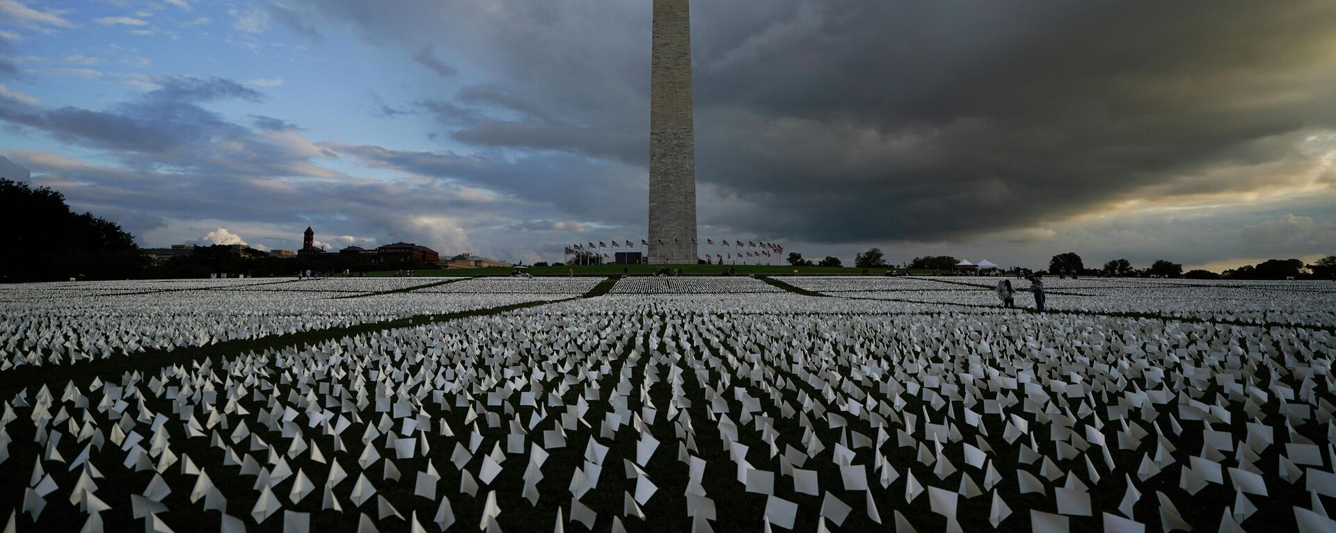 Em Washington, pessoas olham para as bandeiras brancas de uma instalação em memória dos norte-americanos mortos pela COVID-19, em 17 de setembro de 2021 - Sputnik Brasil, 1920, 14.12.2021
