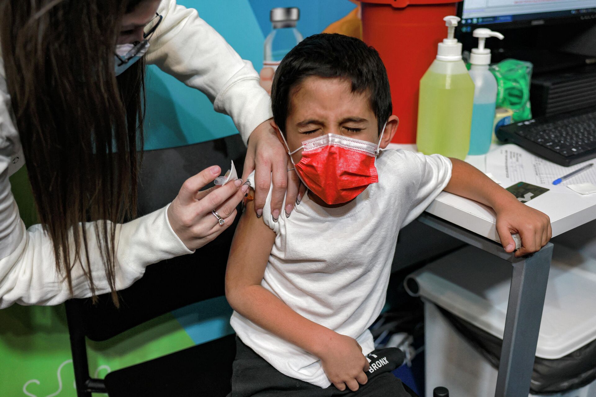 Profissional da saúde israelense aplica uma dose da vacina Pfizer em uma criança de 6 anos em Jerusalém, em 23 de novembro de 2021 - Sputnik Brasil, 1920, 31.12.2021