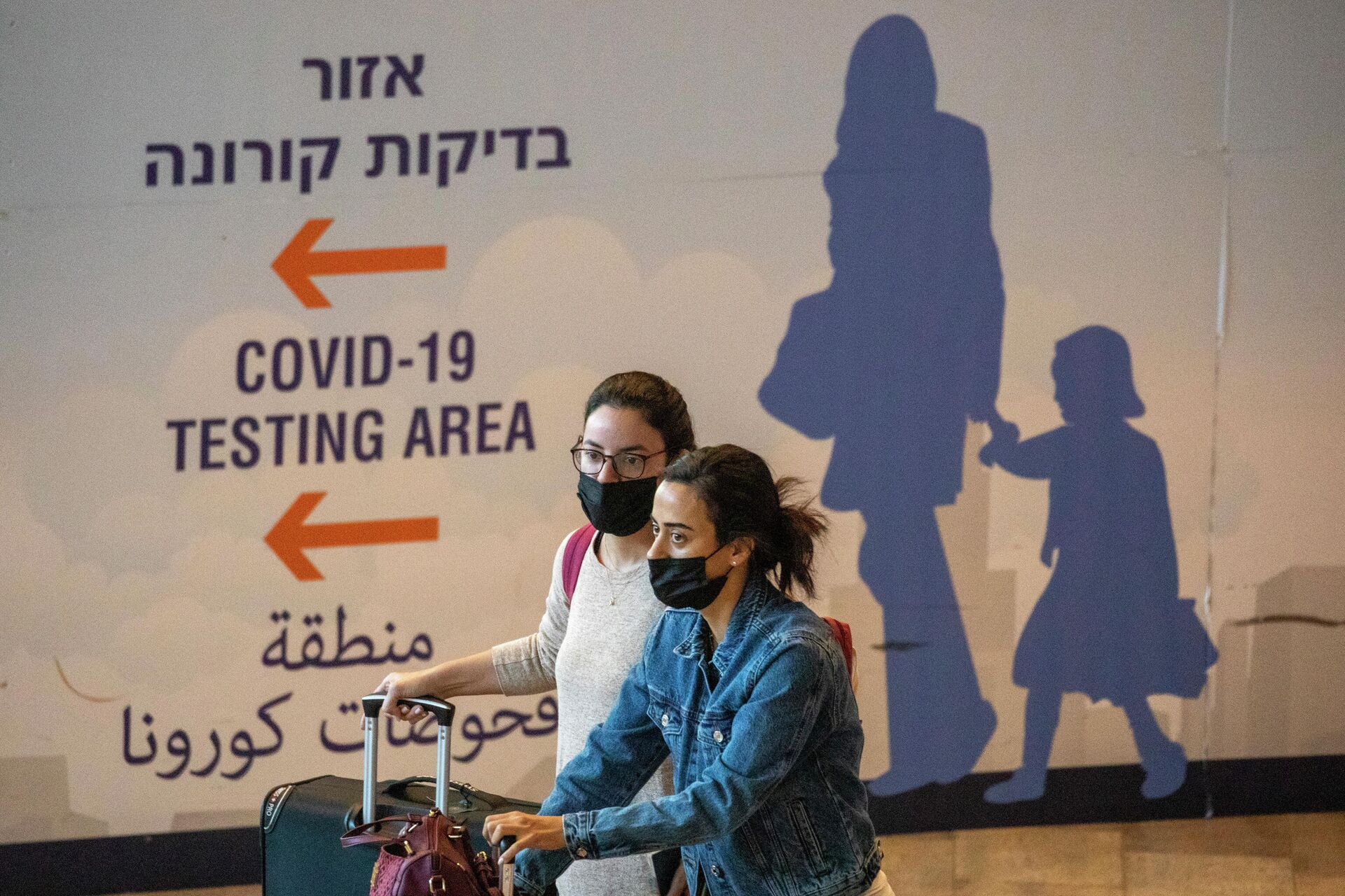 Em Tel Aviv, viajantes usando máscaras contra a COVID-19 chegam ao aeroporto Ben Gurion, em 28 de novembro de 2021 - Sputnik Brasil, 1920, 27.12.2021