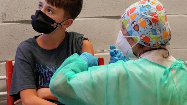 Um menino recebe uma dose da vacina da Pfizer contra a COVID-19 para crianças de 5 a 11 anos, em Roma, na Itália, no dia 15 de dezembro de 2021 - Sputnik Brasil