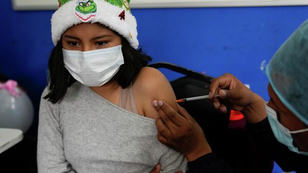 Uma criança recebe uma dose da vacina da Sinopharm durante uma campanha de vacinação para crianças, em La Paz, na Bolívia, no dia 9 de dezembro de 2021 - Sputnik Brasil