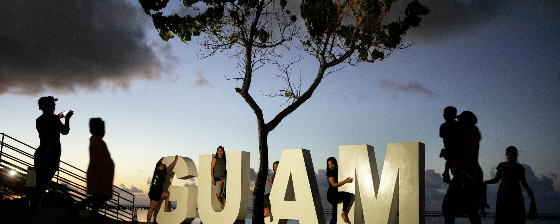 Turistas posam para fotos em uma placa ao longo de uma praia popular em Tamuning, Guam, 11 de maio de 2019 - Sputnik Brasil, 1920, 17.12.2021