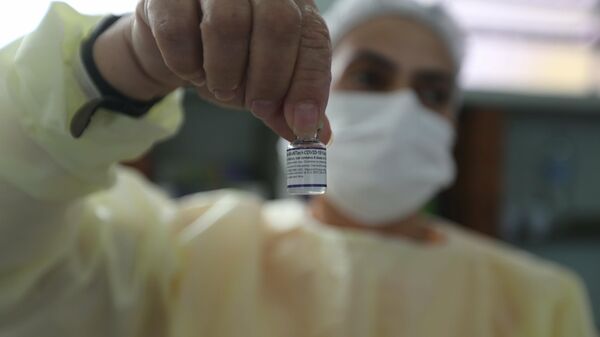 Em São Paulo, uma enfermeira segura um frasco com a vacina contra a COVID-19, em 13 de setembro de 2021 - Sputnik Brasil