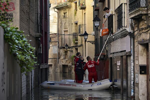 Equipe de resgate ajuda uma mulher em zona inundada perto do rio Ebro, em Tudela, norte de Espanha. - Sputnik Brasil