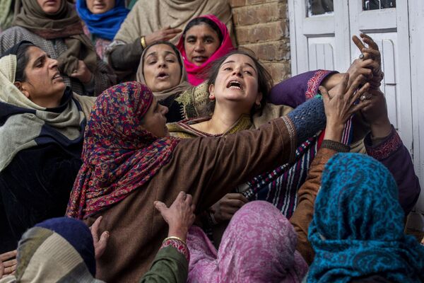 Parentes e vizinhos consolam irmã de Rameez Ahmad, um policial morto em um ataque à mão armada, durante seu funeral em Yachama, a nordeste de Srinagar, na Caxemira administrada pela Índia. - Sputnik Brasil