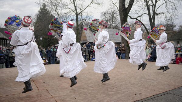 Jovens dançam durante um espetáculo tradicional de inverno no Village Museum em Bucareste, Romênia. - Sputnik Brasil