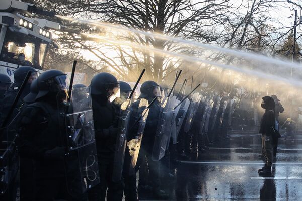 Manifestantes anti-vacinação no Luxemburgo barram canhões d’água da polícia durante uma ação de protesto contra as medidas do governo para conter a propagação da COVID-19. - Sputnik Brasil