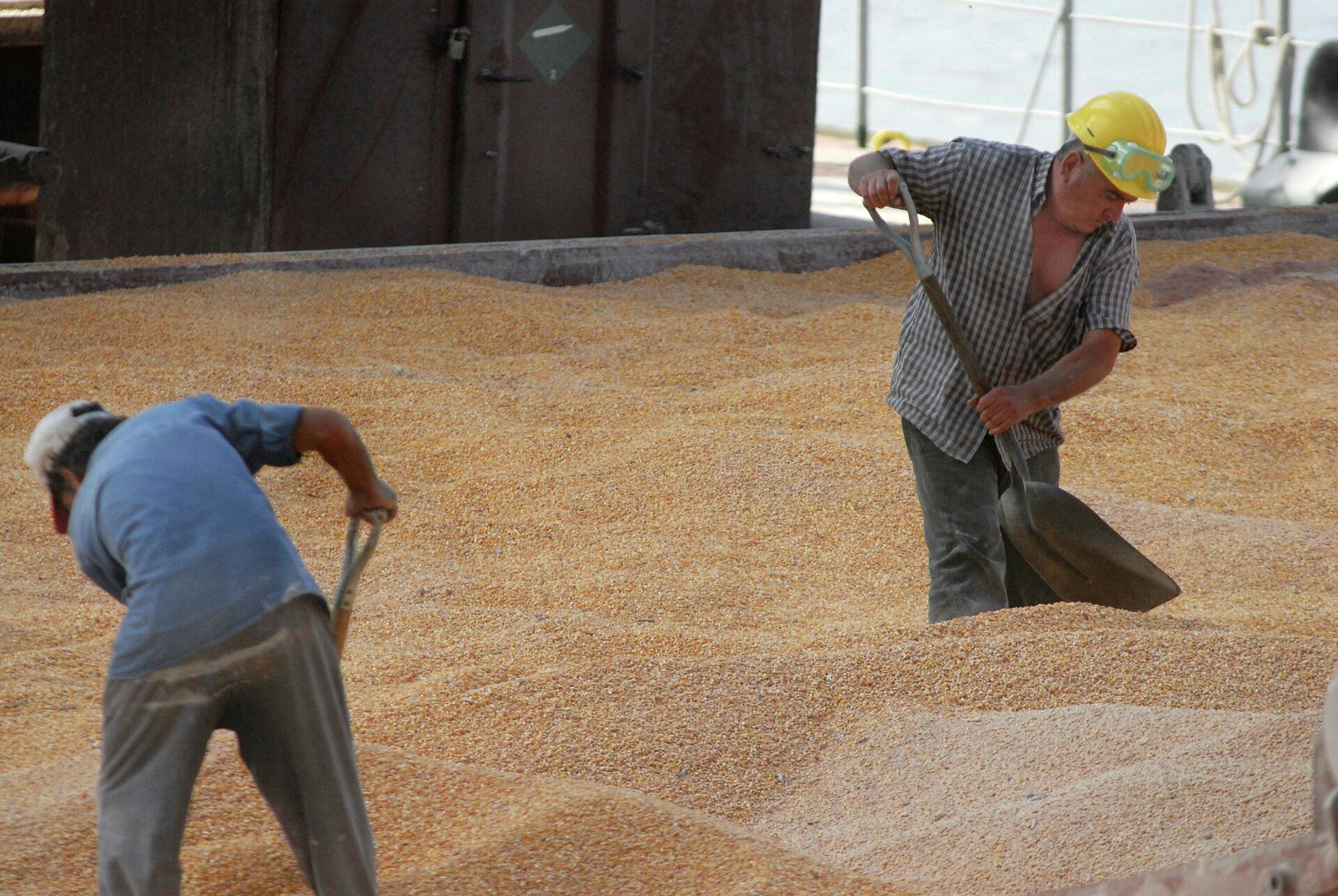 Trabalhadores portuários distribuem milho enquanto carregam em um navio de grãos no porto de Rosário, cerca de 300 quilômetros ao norte de Buenos Aires, Argentina (foto de arquivo) - Sputnik Brasil, 1920, 15.03.2022