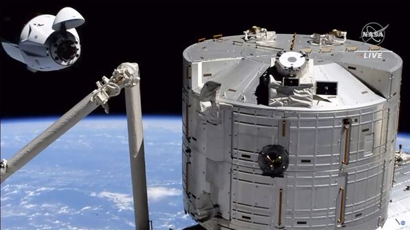 Espaçonave Crew Dragon da Space X, à esquerda, se aproximando da Estação Espacial Internacional, 24 de abril de 2021. - Sputnik Brasil