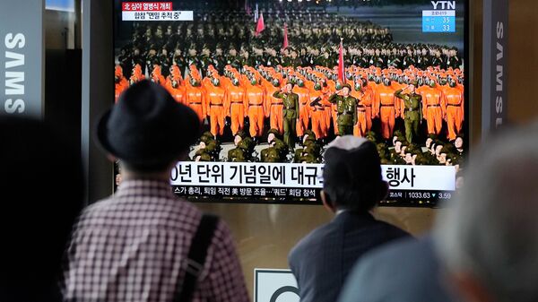 Pessoas assistem a uma TV que mostra um desfile militar realizado em Pyongyang, Coreia do Norte, na Estação Ferroviária de Seul em Seul, Coreia do Sul, quinta-feira, 9 de setembro de 2021 - Sputnik Brasil
