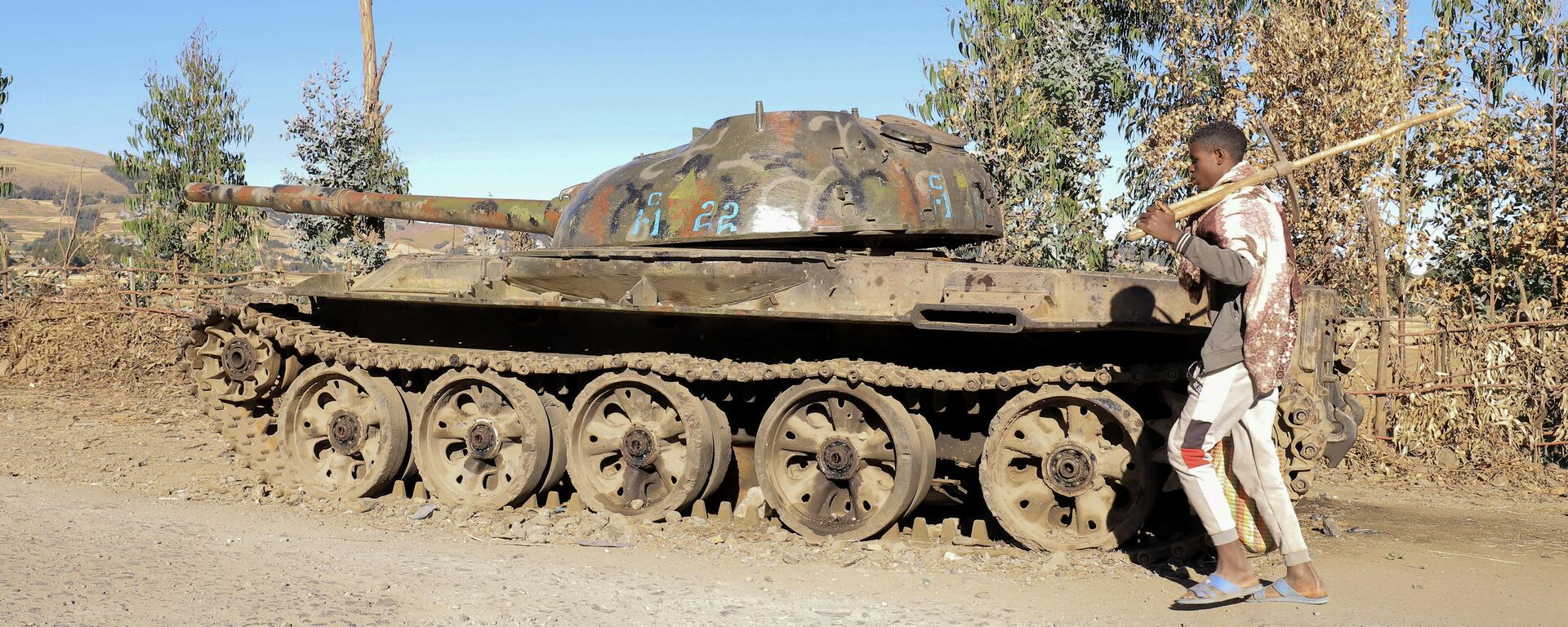 
Fazendeiro passa ao lado de tanque destruído durante a guerra entre o governo da Etiópia e militantes da região de Tigré, estado de Amhara, Etiópia, 7 de dezembro de 2021 - Sputnik Brasil, 1920, 23.12.2021