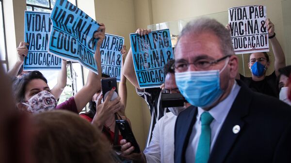 Em São Paulo, o ministro da Saúde brasileiro, Marcelo Queiroga, concede entrevista enquanto estudantes realizam protesto contra, em 25 de março de 2021 - Sputnik Brasil