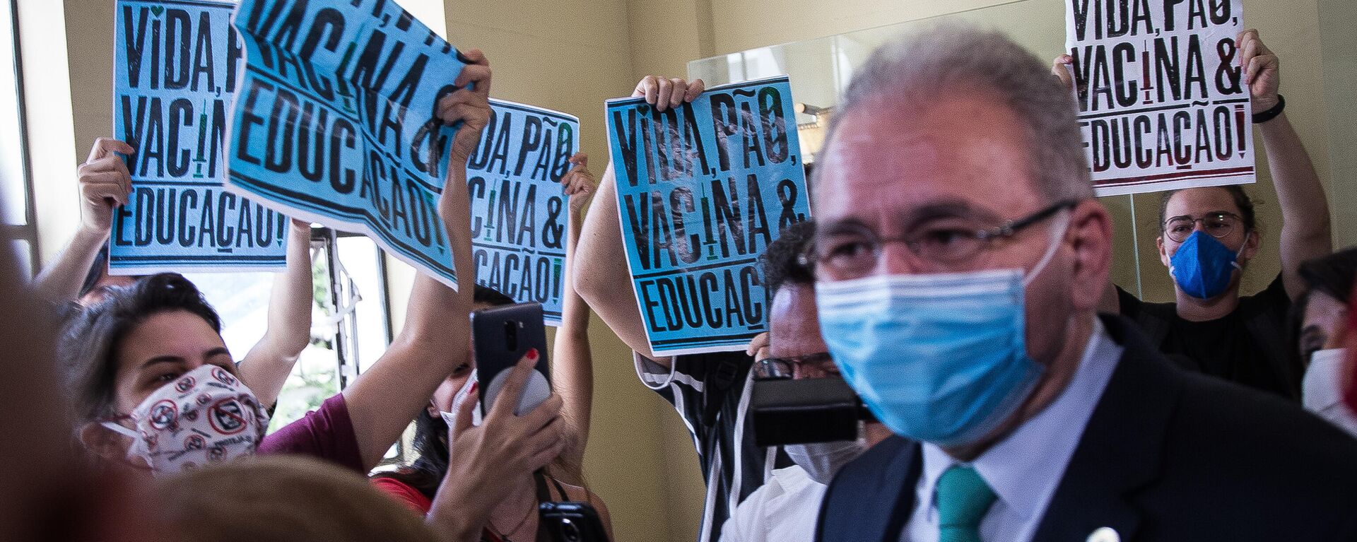 Em São Paulo, o ministro da Saúde brasileiro, Marcelo Queiroga, concede entrevista enquanto estudantes realizam protesto contra, em 25 de março de 2021 - Sputnik Brasil, 1920, 23.12.2021