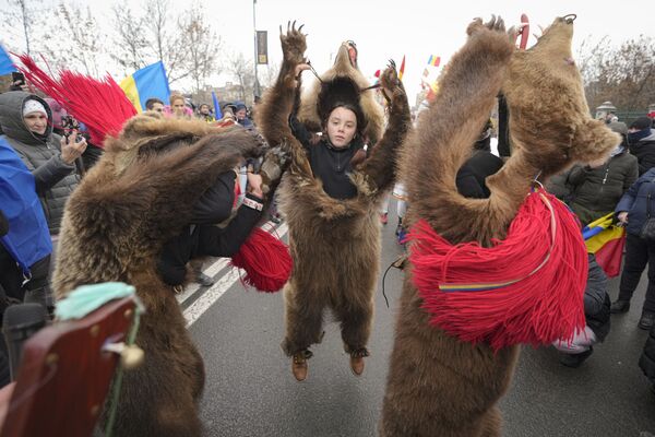 Manifestantes contra novas medidas anti-COVID-19 junto do Parlamento romeno, acompanhados por um grupo de pessoas disfarçadas de ursos, em Bucareste, Romênia, 21 de dezembro de 2021. - Sputnik Brasil