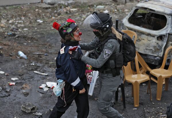 Manifestante discute com agente das forças de segurança de Israel durante protestos no leste de Jerusalém, 17 de dezembro de 2021. - Sputnik Brasil