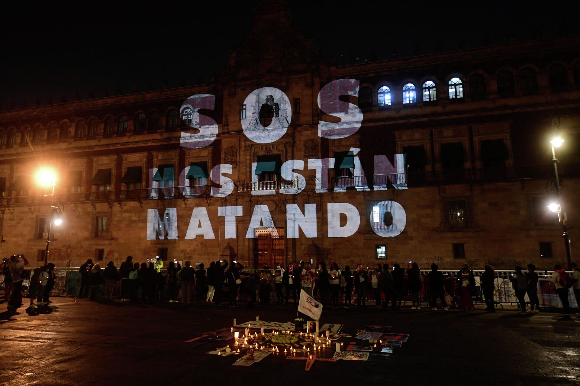 As palavras SOS, eles estão nos matando são projetadas no Palácio Nacional. Pessoas se reúnem durante uma vigília com parentes de vítimas de feminicídio e desaparecimentos forçados na Cidade do México, México, em 28 de março de 2021 - Sputnik Brasil, 1920, 26.12.2021