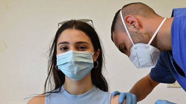 Em Lampedusa, na Itália, uma mulher é vacinada contra a COVID-19, em 15 de maio de 2021 - Sputnik Brasil