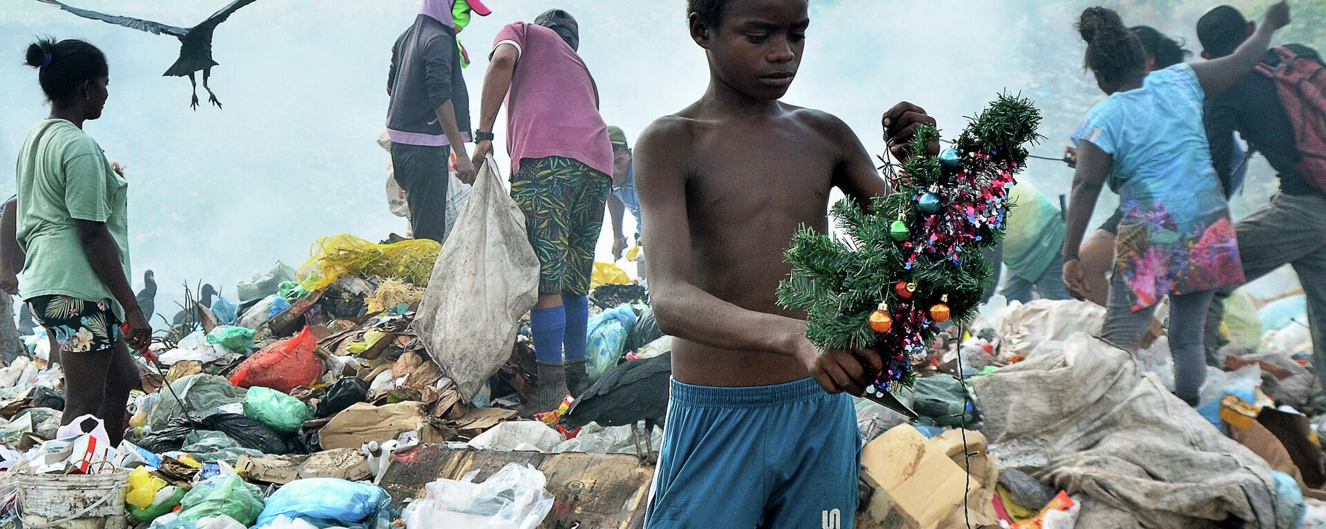 Menino segura uma decoração de Natal que encontrou enquanto vasculhava o lixo no aterro de Picarreira, em Pinheiro, estado do Maranhão, em 08 de novembro de 2021 - Sputnik Brasil, 1920, 27.12.2021