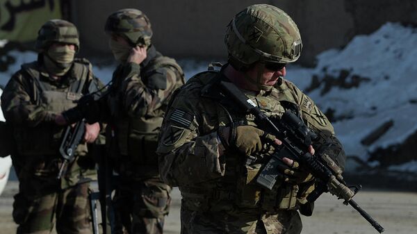 Dois soldados franceses (esquerda) e um soldado dos EUA, parte da Força Internacional de Apoio à Segurança (ISAF), liderada pela OTAN, montam guarda no local de um ataque com carro-bomba na área de Pol-e-Charkhi, em Cabul, em 10 de fevereiro de 2014 - Sputnik Brasil