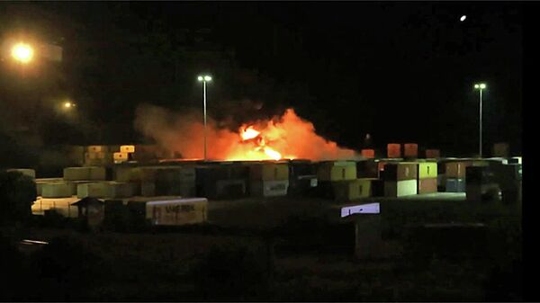 Uma imagem capturada de um vídeo divulgado pela Agência de Notícias Árabe Síria (SANA), em 7 de dezembro de 2021, mostra um incêndio perto de contêineres no porto de Latakia, na Síria - Sputnik Brasil